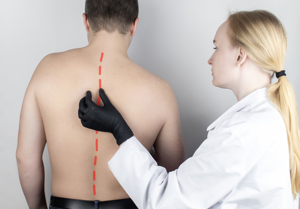 Imagem das Costas de um homem, sendo examinado por uma médica