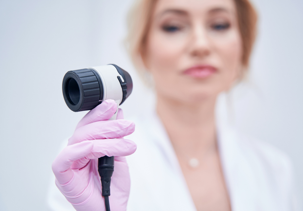 Médica com um aparelho dermatoscópio