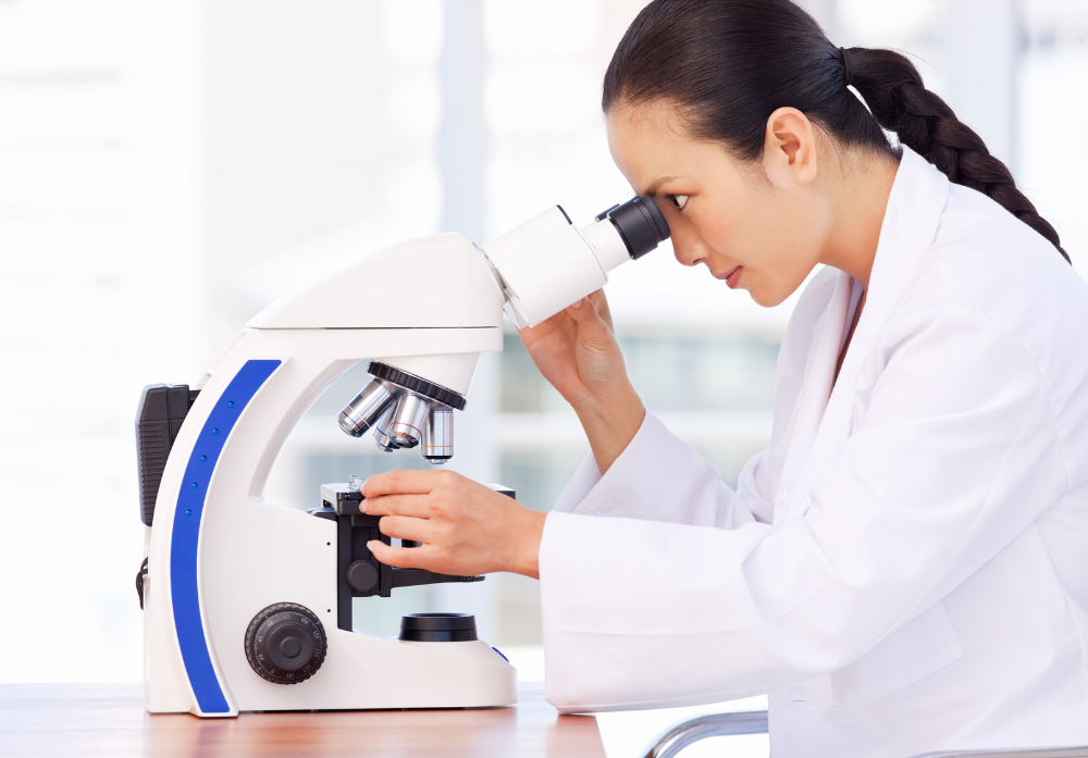 Médica Oriental observando um microscópio