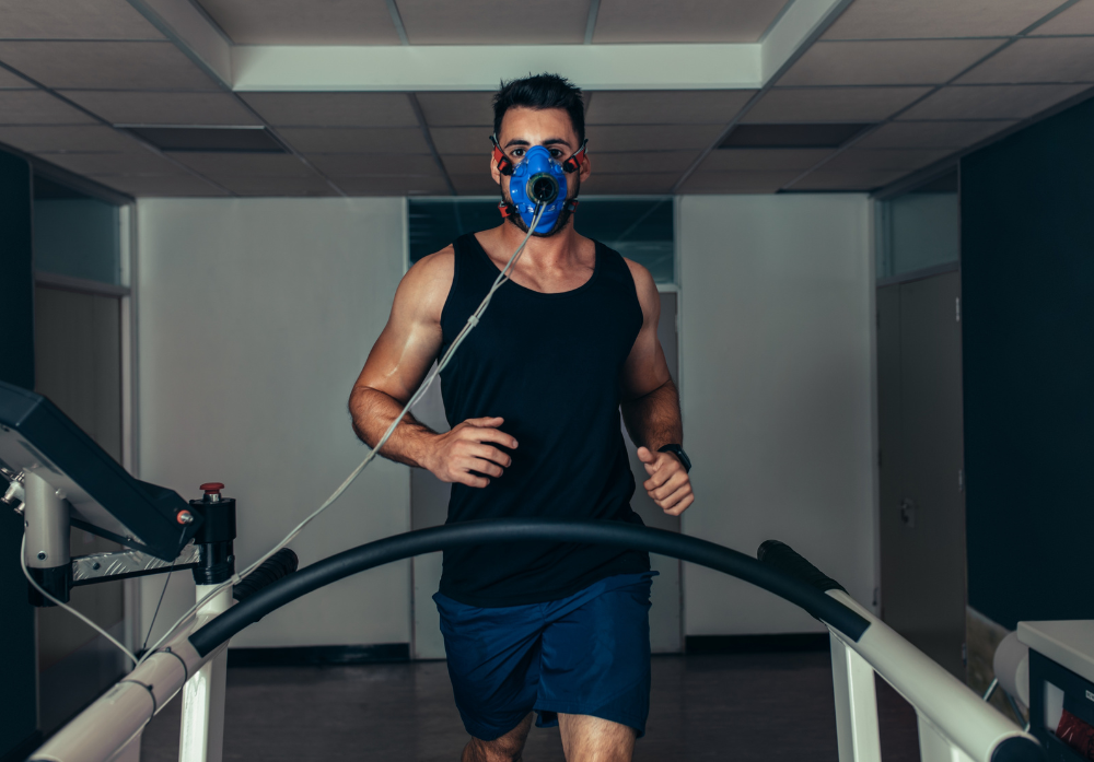 Homem correndo em uma esteira, usando máscara respiratória