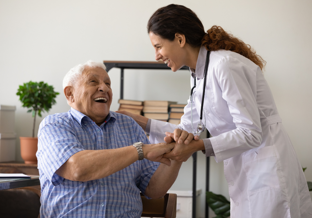 Médica auxiliando um idoso a se mover